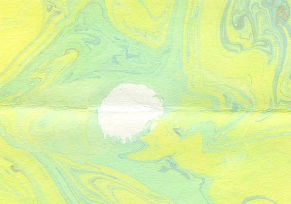 a piece of yellow and green paper marbling with a white air bubble space in the middle
