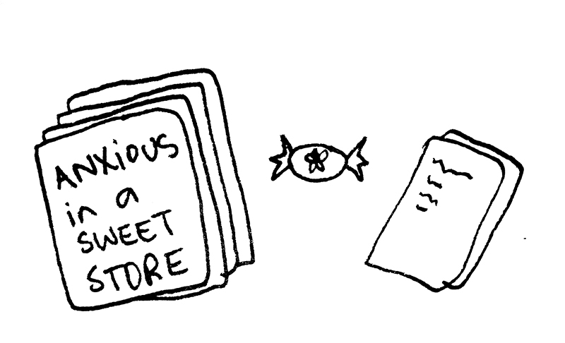 a drawing of a manuscript titled anxious in a sweet store, resting next to a wrapped lolly