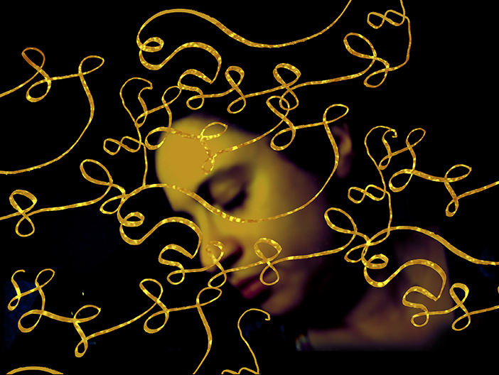 an art self-portrait by Anna Jacobson with brushstrokes of golden thread weaving over her face and closed eyes and the darkened background.