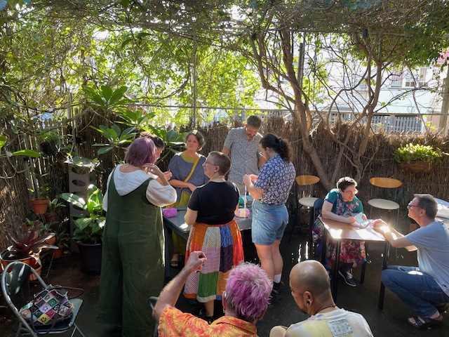 a photo of the sun-drenched courtyard where a crafternoon takes place. Anna is signing a copy of her book.